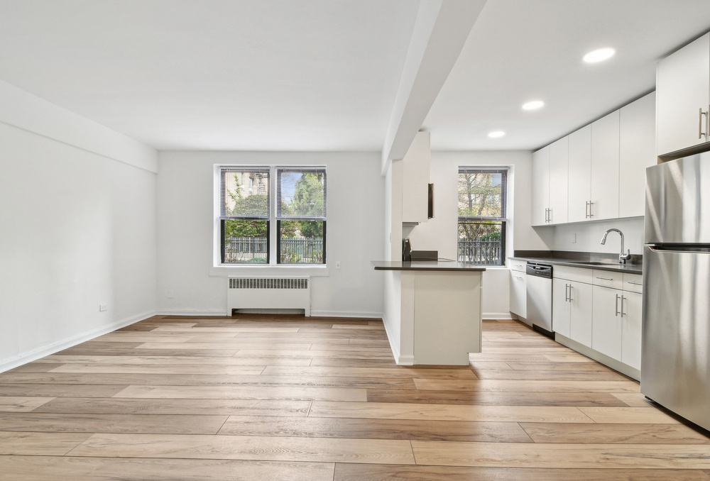 Living room with hardwood floors and open kitchen with breakfast bar